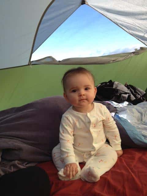 baby in pajamas sitting in tent