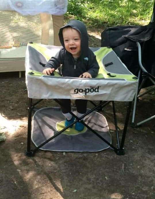 baby in portable play area while camping