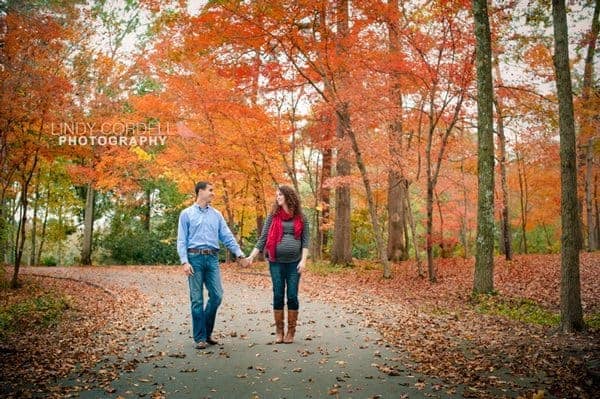 couple holding hands in a fall maternity session