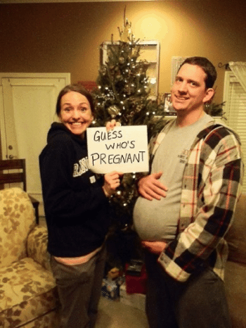 woman holding guess who's pregnant sign with fake bump on dad fun pregnancy announcement