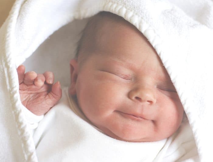newborn baby wrapped up in a white blanket