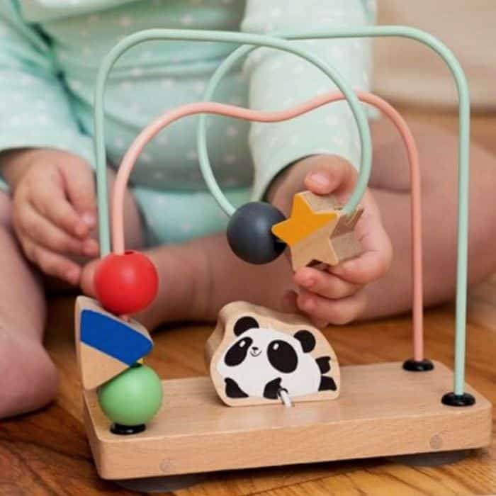 Baby playing with wire maze toy