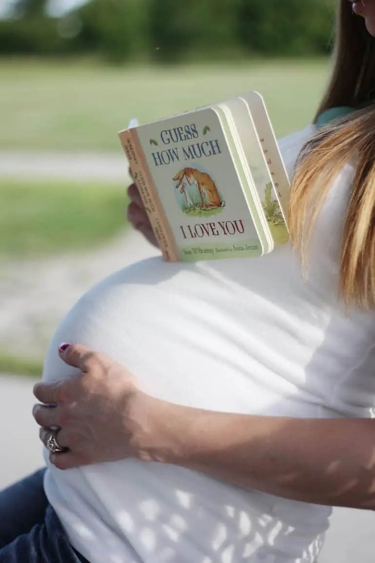 pregnant woman holding board book on bump