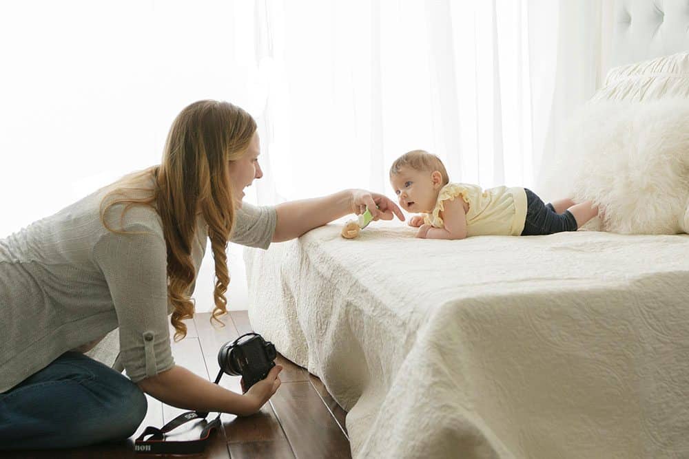 mom helping baby lift head for home photoshoot