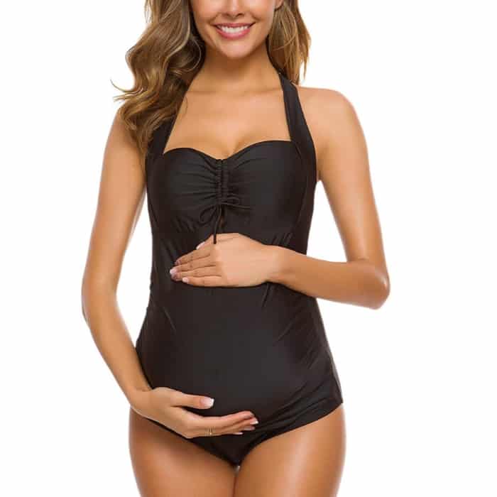 woman holding pregnancy bump in black inexpensive one piece swim suit
