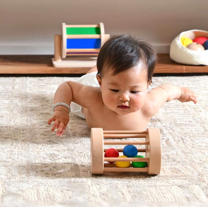 baby looking at wooden toy in Montessori play nursery