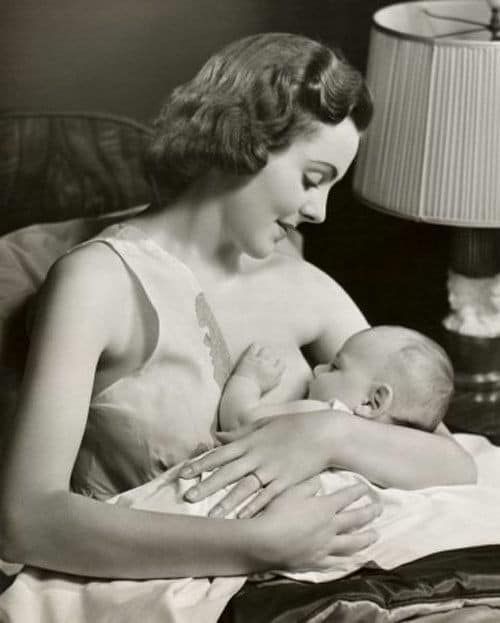 Black and white photograph of mother breastfeeding baby