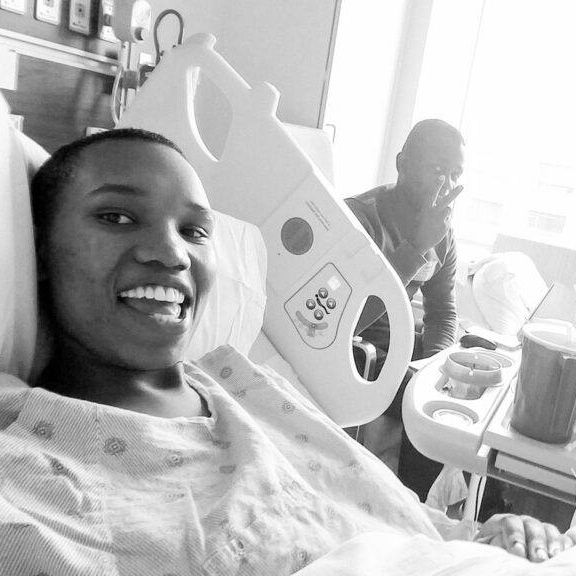 pregnant woman in the hospital taking a selfie with her husband after having a cervical cerclage