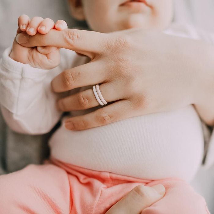 mom wearing pregnancy friendly silicone rings holding baby