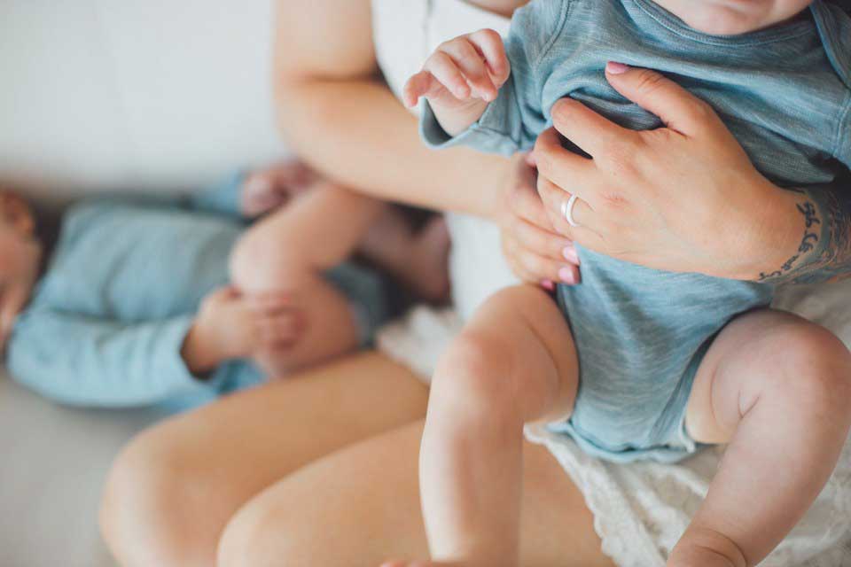 mom holding baby's head wearing enso rings - perfect pregnancy friendly jewelry