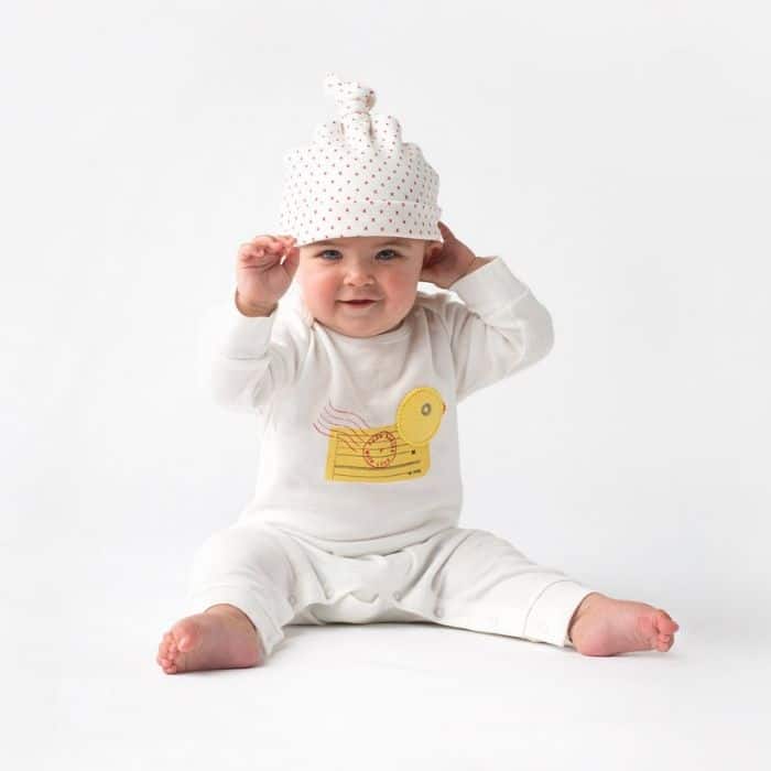 Baby wearing soft white organic outfit from Babies With Love