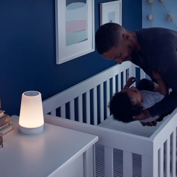 dad putting baby in crib with nightlight on side table at night, Hatch Rest Plus Review
