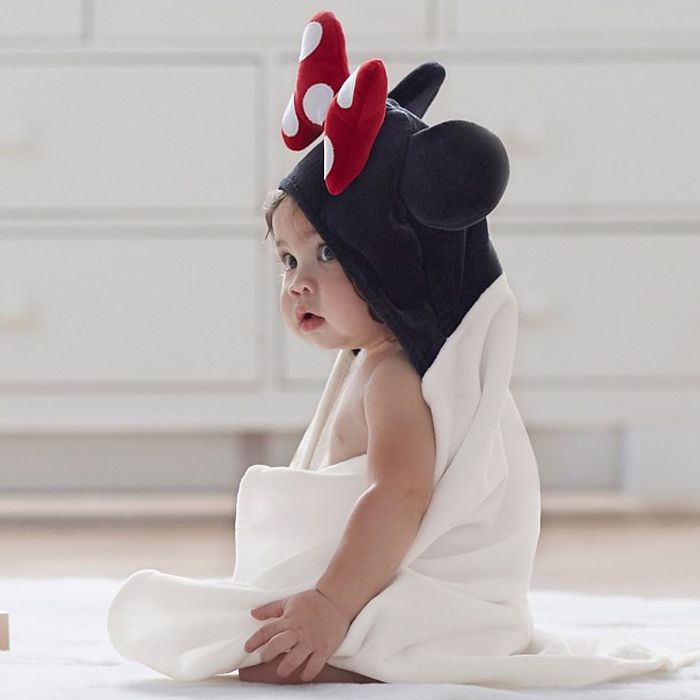 Baby sitting wrapped up in Minnie Mouse hooded towel