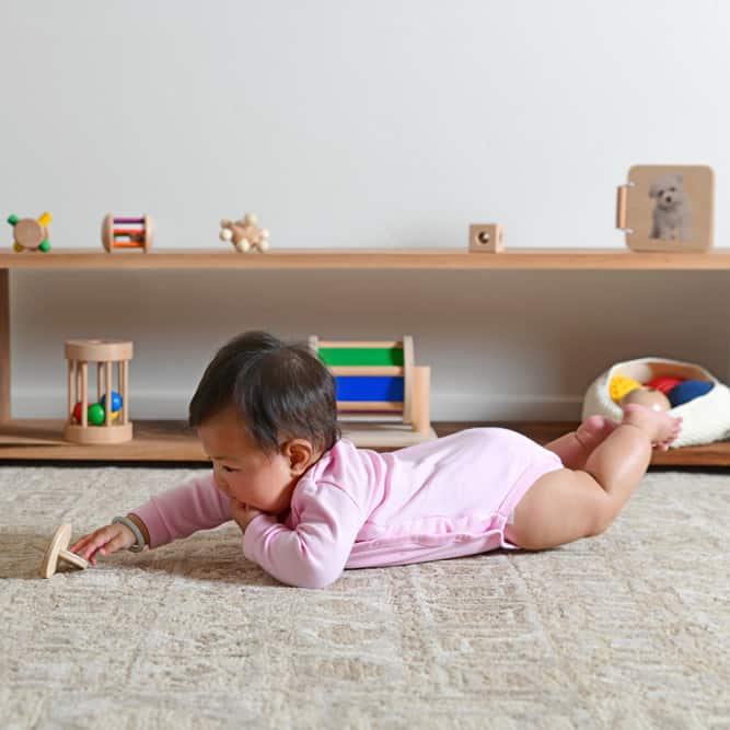 baby playing with a wooden toy in a Montessori play room