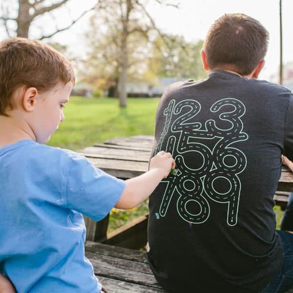 child using car to trace numbers on his dad's T-shirt - father's day gift