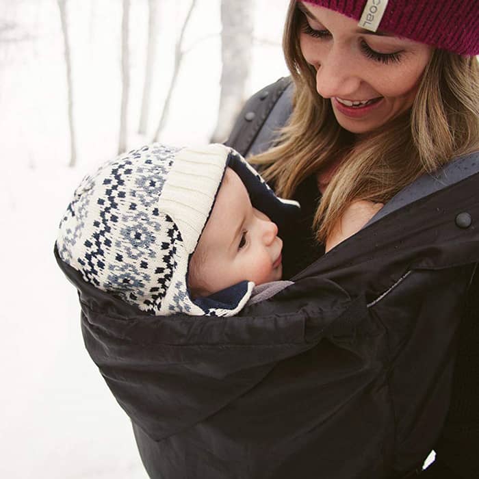 mom holding baby in carrier in the winter