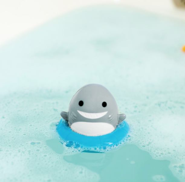 Munchkin Sea Spinner Wind-Up Shark Bath Toy in bathtub surrounded by bubbles