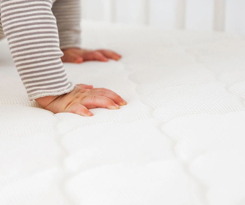 baby hands on Newton Wovenaire Crib Mattress