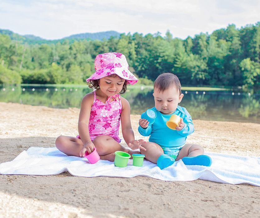 baby and toddler in sun wear at the beach