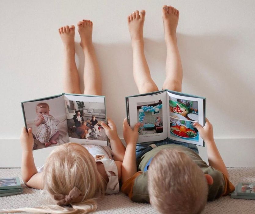 two kids with feet on the wall looking at chatbooks