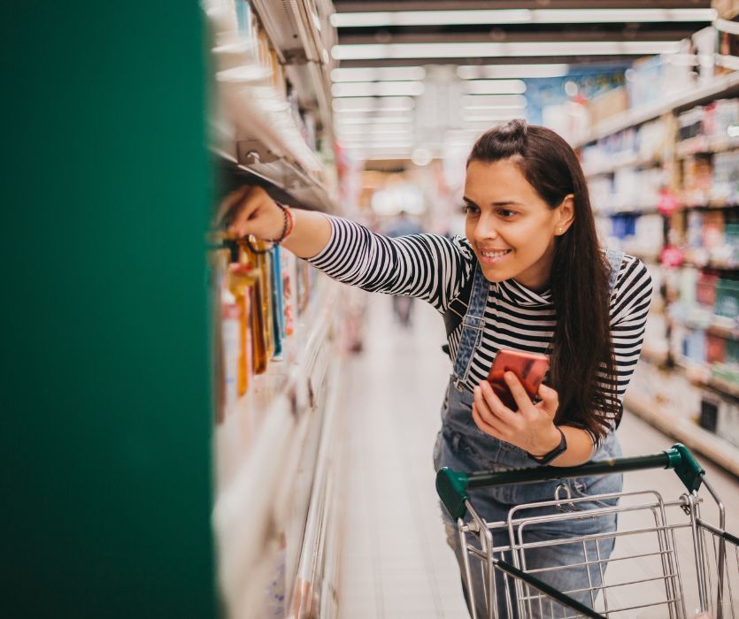 woman in store shopping with a grocery cart