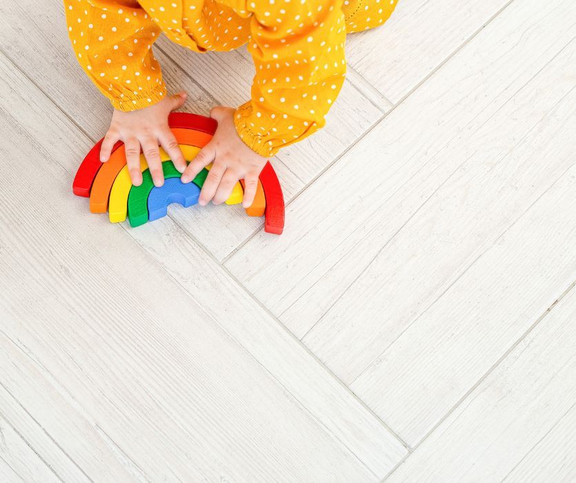 toddler playing with wooden rainbow toy