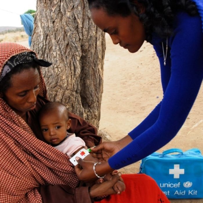 medical worker from unicef helping mom and baby
