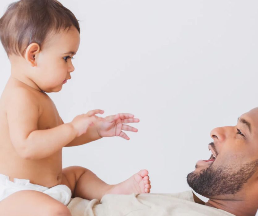 dad holding baby wearing dyper diapers