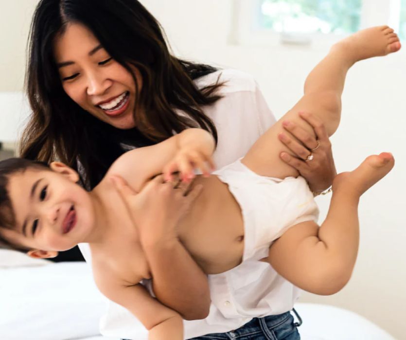 mom holding toddler wearing dyper diapers